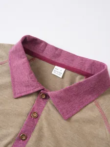 Close-up detail of contrast collar polo shirt in khaki and magenta with button placket.