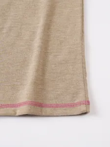 Close-up detail of the breathable fabric hem with contrast pink stitching on the summer top.