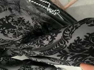 Close-up detail of medieval vintage velvet lace patchwork dress fabric texture and craft.