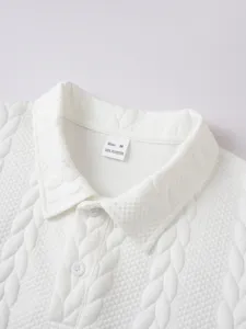 Close-up detail of white knitted texture polo shirt collar with buttons and size tag.
