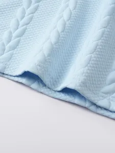 Close-up van de lichtblauwe getextureerde stof met een prachtig gewatteerd ruitpatroon.