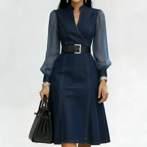 Women's chic denim midi dress with sheer long sleeves, stand collar, and stylish black belt.