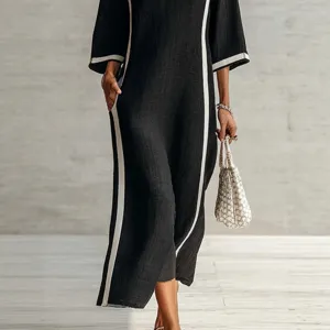 Elegant black long sleeve maxi dress with striking white side stripes and convenient pockets.