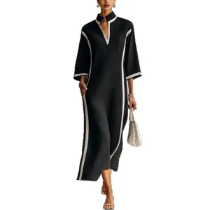 Elegant black maxi dress with white contrast trim, stand collar, and comfortable 3/4 sleeves.