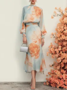Detail shot of the gorgeous blue floral chiffon dress featuring elegant puff sleeves and backdrop.