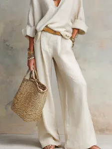 Detail view of the linen resort outfit featuring texture, stitching, and draped wide leg pants.