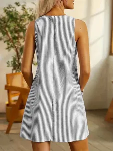 Detail view of women's sleeveless black and white vertical striped dress in home setting.