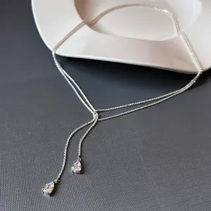 Gros plan détaillé de la chaîne de taille scintillante en argent avec de délicats pendentifs.