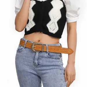 Close-up of a retro brown PU leather women belt with ornate metal buckle and embroidery design.