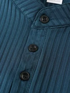 Vue détaillée du tissu en tricot côtelé bleu foncé et des boutons noirs mode.