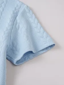 Light blue jacquard short sleeve polo shirt fabric detail and neat cuff close-up view.