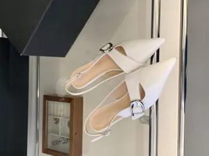 Stylish white pointed-toe slingback heels with silver buckle for women, chic and elegant.