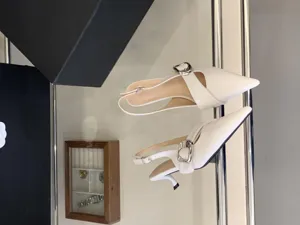 Chic white pointed-toe slingback kitten heels with elegant metal buckle for women.