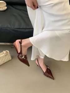 Burgundy pointed-toe slingback kitten heels with metal buckle, stylish detail shot.