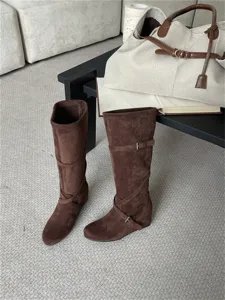 Botas altas marrones de ante con hebillas elegantes y cuña para la moda de otoño.