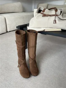 Botas altas de ante marron con hebilla y diseño plisado suave para mujeres en otoño.