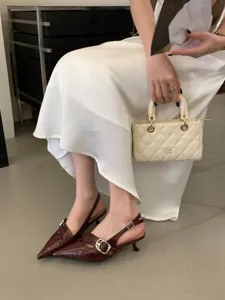 Stylish pointed-toe slingback kitten heels paired with a quilted mini handbag for elegant wear.