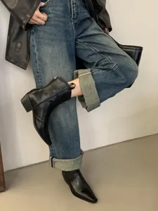 Detail view of stylish black pointed-toe western ankle boots with chunky heel for women.