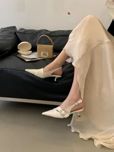 Elegant pointed toe slingback kitten heels detail shot, classic white women fashion dress shoes.