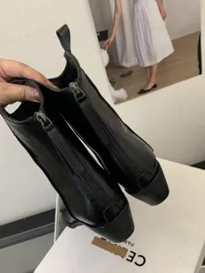 Women's black short boots featuring a chic pointed toe, chunky heel, and sleek back zipper design.