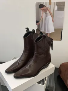 Brown pointed toe western cowboy boots detail with chunky heels and V-cut design.