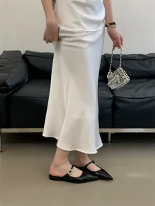 Vue détaillée de mules plates pointues noires avec bride à boucle en cristal étincelante.