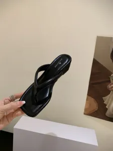 Detailansicht schwarzer Zehentrenner mit quadratischer Kappe und minimalistischem Design.