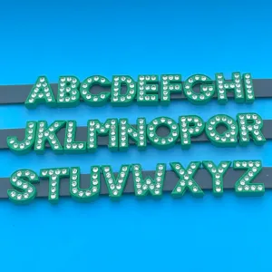 Green rhinestone alphabet letters detail view, sparkling DIY charm accessories for bracelets.