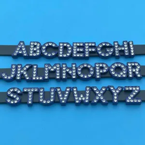 Close-up detail of blue rhinestone alphabet letter charms for DIY jewelry making accessories.
