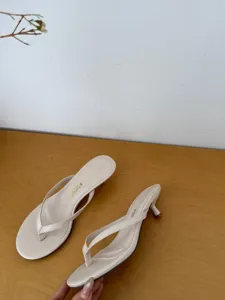 Detail view of summer minimalist thong kitten heel sandals in beige, elegant and stylish design.