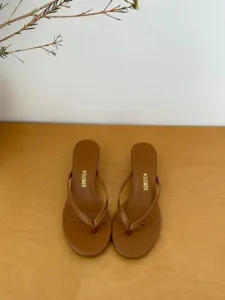 Brown kitten heel thong sandals detail, minimalist summer footwear close-up view.