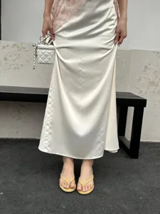 Detail view of summer casual thong sandals paired with satin skirt and stylish accessories.