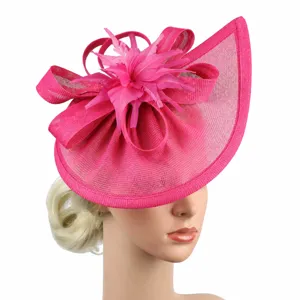 Detail view of the hot pink fascinator hat, featuring mesh, bow, and feather accent for event.