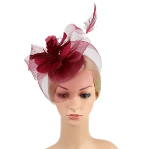 Close-up detail showcasing the delicate feather and mesh veil of the elegant burgundy fascinator.