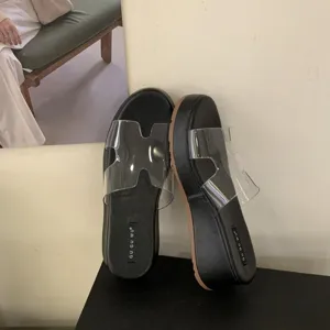 Detailed shot of trendy women's clear PVC wedge platform slide sandals for summer wear.