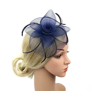 Vue détaillée de l'élégant chapeau fascinateur en maille bleu marine avec plumes et rose.