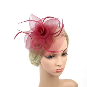 Detail fascinateur fleur en filet bordeaux, elegant accessorio cheveux avec plumes chic.