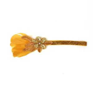 Gold feather rhinestone headband detail view, showing delicate sequin flower and shiny band.