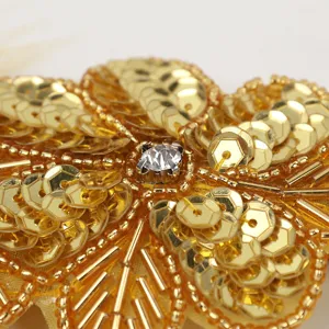 Detailed macro shot of gold sequin flower hair accessory with a sparkling central crystal.