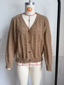 Close-up of hollow-out knit cardigan texture, showing V-neck design and button details clearly.