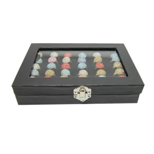 Black ring display box with glass lid and colorful rhinestone rings for jewelry store.