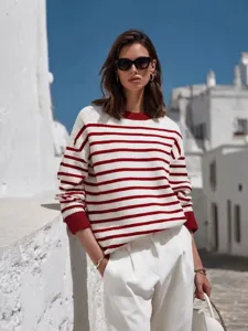Detailed view of women's red and white striped knit sweater featuring contrast cuffs.