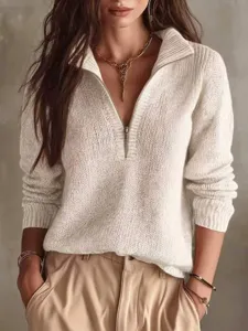 Close-up detail of women's half-zip knitted sweater with ribbed texture and chic collar style.