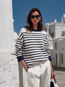 Chic striped knit sweater detail in Mediterranean street style, cozy textured fabric.