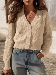 Close-up detail of beige cable knit cardigan with V-neck, buttons and chic raw hem design.