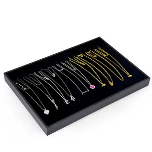 Detailed close-up view of fashion necklaces on black velvet display tray, luxury jewelry.
