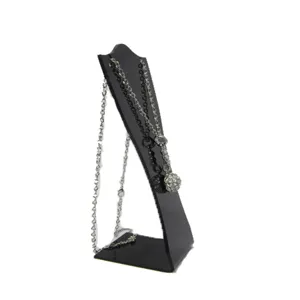 Vue de détail du présentoir de collier en acrylique noir avec support inclinable et base solide.