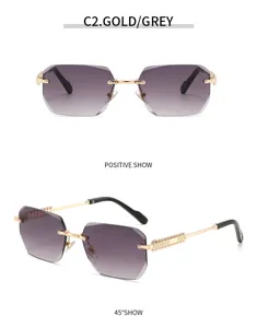 Close-up of luxury polygonal rimless sunglasses with gradient grey lenses and gold ornate temples.