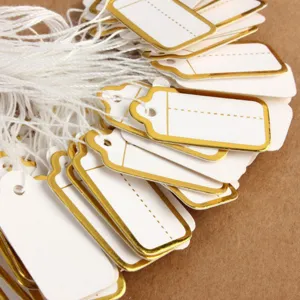 White paper price hang tags featuring elegant gold foil borders and attached strings for jewelry.