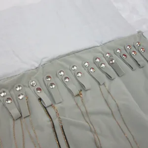 Gros plan détaillé de l'organisateur de bijoux en velours gris avec boutons-pression.